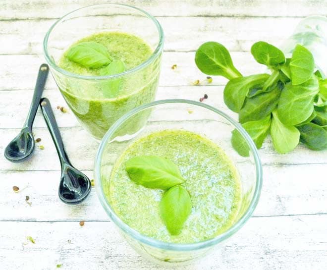 Grüner Smoothie im Glas, dekoriert mit Basilikumblättern