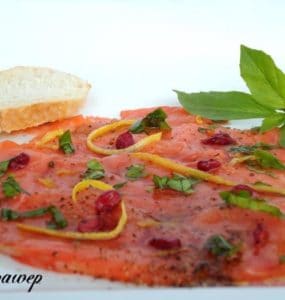 Lachscarpaccio mit Granatapfelkernen, Zesten einer Zitrusfrucht und Basilikum