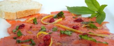 Lachscarpaccio mit Granatapfelkernen, Zesten einer Zitrusfrucht und Basilikum