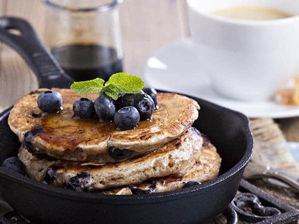 Pancakes in einer schwarzen Pfanne mit Blaubeeren garniert