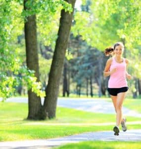 Joggerin läuft durch einen grünen Park