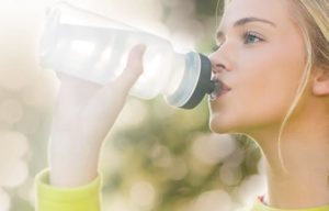 Frau trinkt Wasser aus Flasche