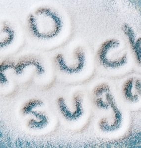 Die Worte Too much sugar geschrieben in eine Fläche ausgestreuten Zuckers