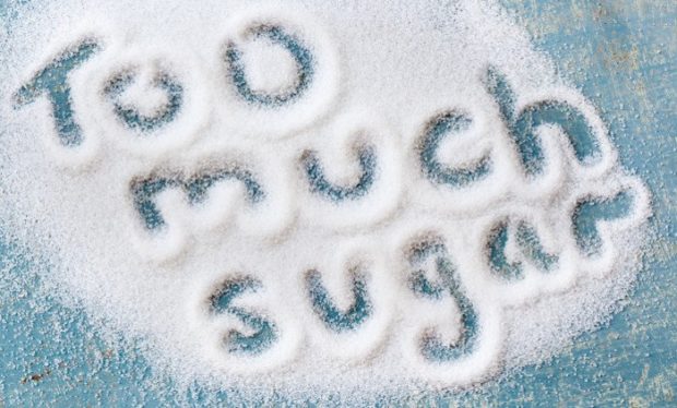 Die Worte Too much sugar geschrieben in eine Fläche ausgestreuten Zuckers