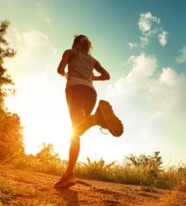 Frau joggt in den Sonnenuntergang.