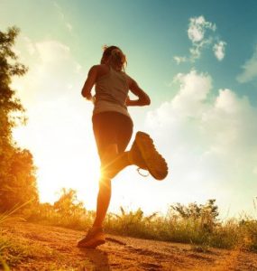 Frau joggt in den Sonnenuntergang.