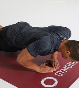 Mann macht Diamond Push Ups auf dunkelroter Trainingsmatte