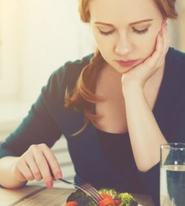 Frau stochert lustlos im Salat