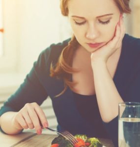 Frau stochert lustlos im Salat