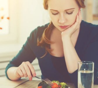 Frau stochert lustlos im Salat