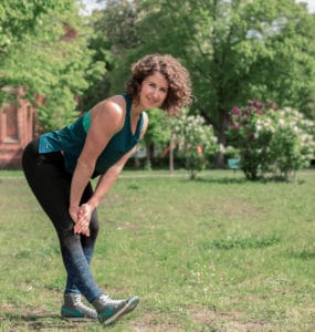 Junge Frau auf einer Raststätte macht Übung Bein Stretch