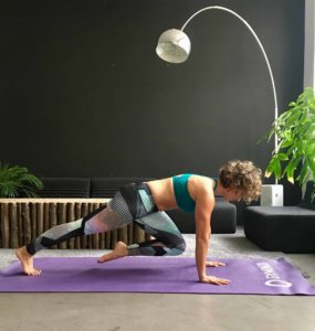 Frau macht Mountain Climbers auf lila trainingsmatte