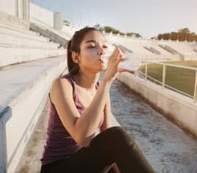 Sportlerin trinkt Wasser nach dem Workout.