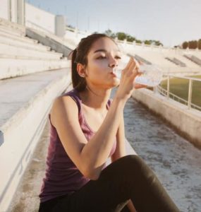 Sportlerin trinkt Wasser nach dem Workout.