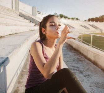 Sportlerin trinkt Wasser nach dem Workout.