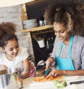 Mutter und Kind kochen gemeinsam gesund in der Küche