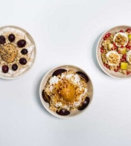 3 weiße Schalen mit Haferbrei garniert mit Früchten und Nüssen, Oat Meal Bowls