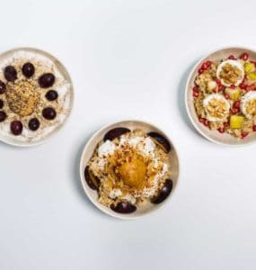 3 weiße Schalen mit Haferbrei garniert mit Früchten und Nüssen, Oat Meal Bowls