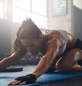 Junge, athletische Frau macht Yoga für Sportler - die Haltung des Kindes