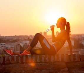 Sportlerin sitzt auf Mauer