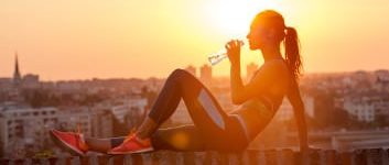 Sportlerin sitzt auf Mauer