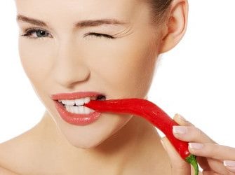 Frau mit Chilischote: Natürliche Antibiotika in Lebensmitteln