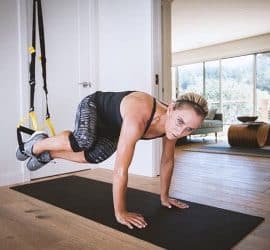 Sportlerin mit dem TRX im Wohnzimmer