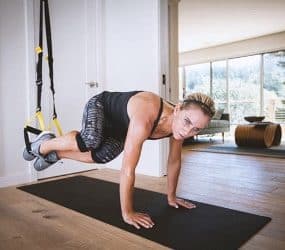 Sportlerin mit dem TRX im Wohnzimmer