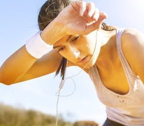 Frau beim Joggen ist müde und schlapp