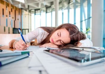 Frau schläft auf Schreibtisch