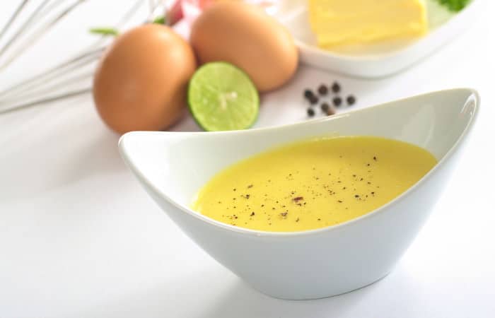 Kalorienarme Sauce Hollandaise in weißer Keramikschüssel