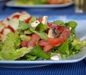 Grüner Sommersalat mit Tomaten, Feta und Pilzen an einem Mango-Pfirsich-Dressing