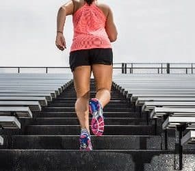 Sportlerin macht Tabata Training auf einer Treppe.