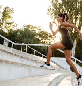 Junge sportliche Frau rennt eine Treppe hoch